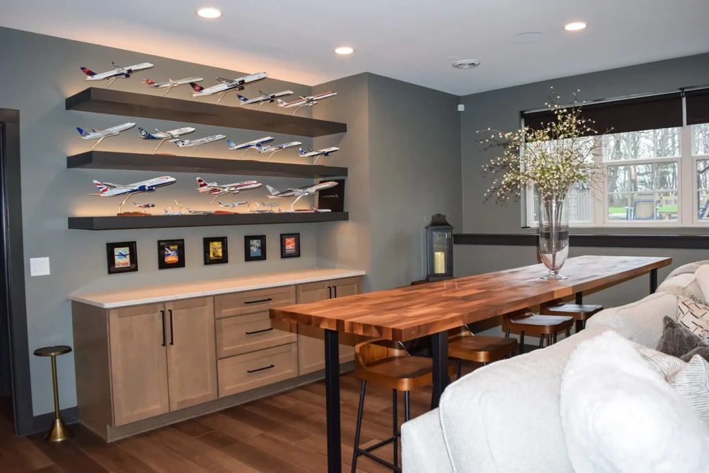 Finished basement lounge with model airplane display and wood table