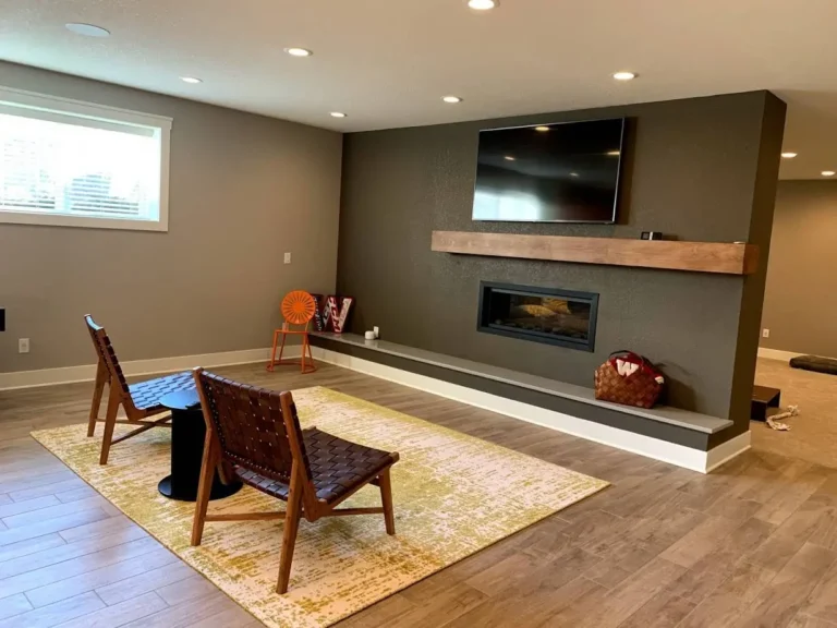 Finished basement living room with wall-mounted TV and fireplace