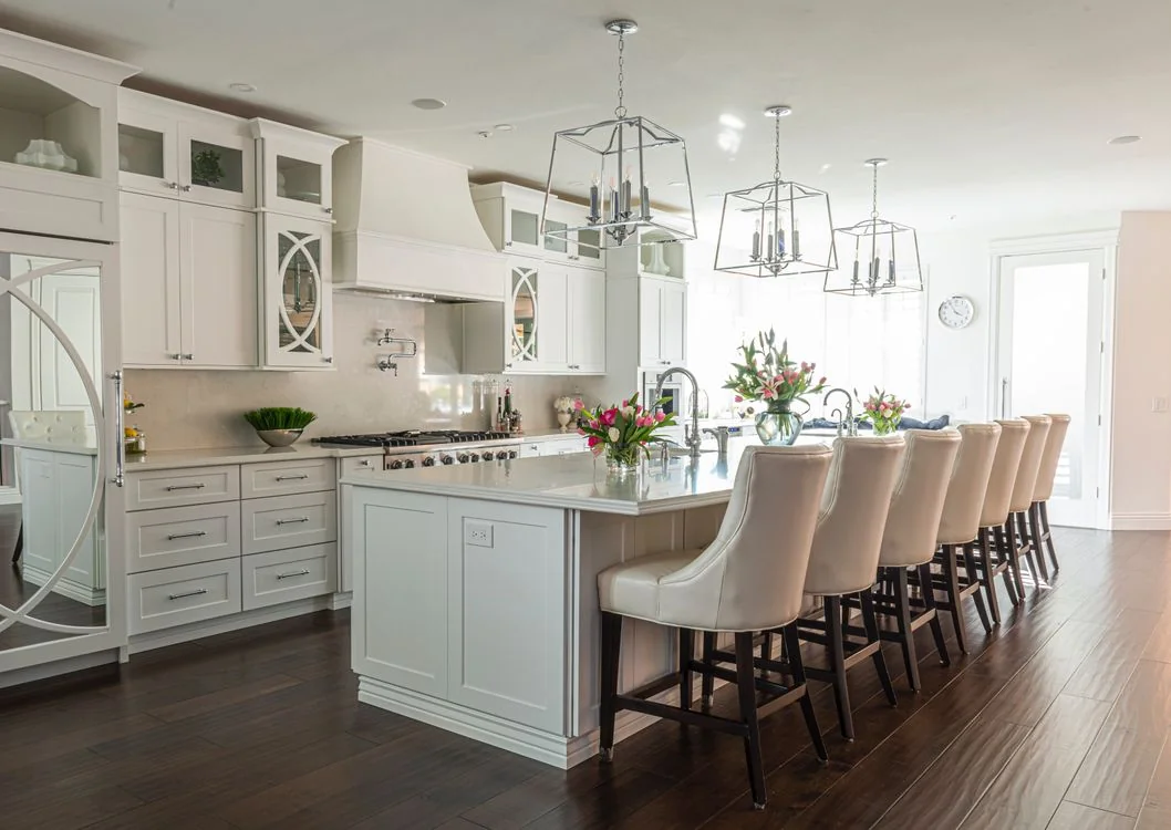 Modern kitchen with white cabinets, a central island and bar stools