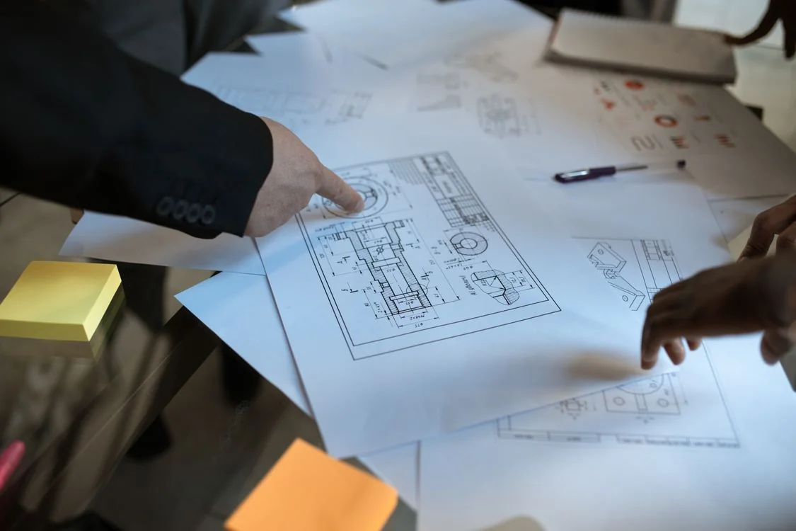 Hands reviewing architectural plans at a table